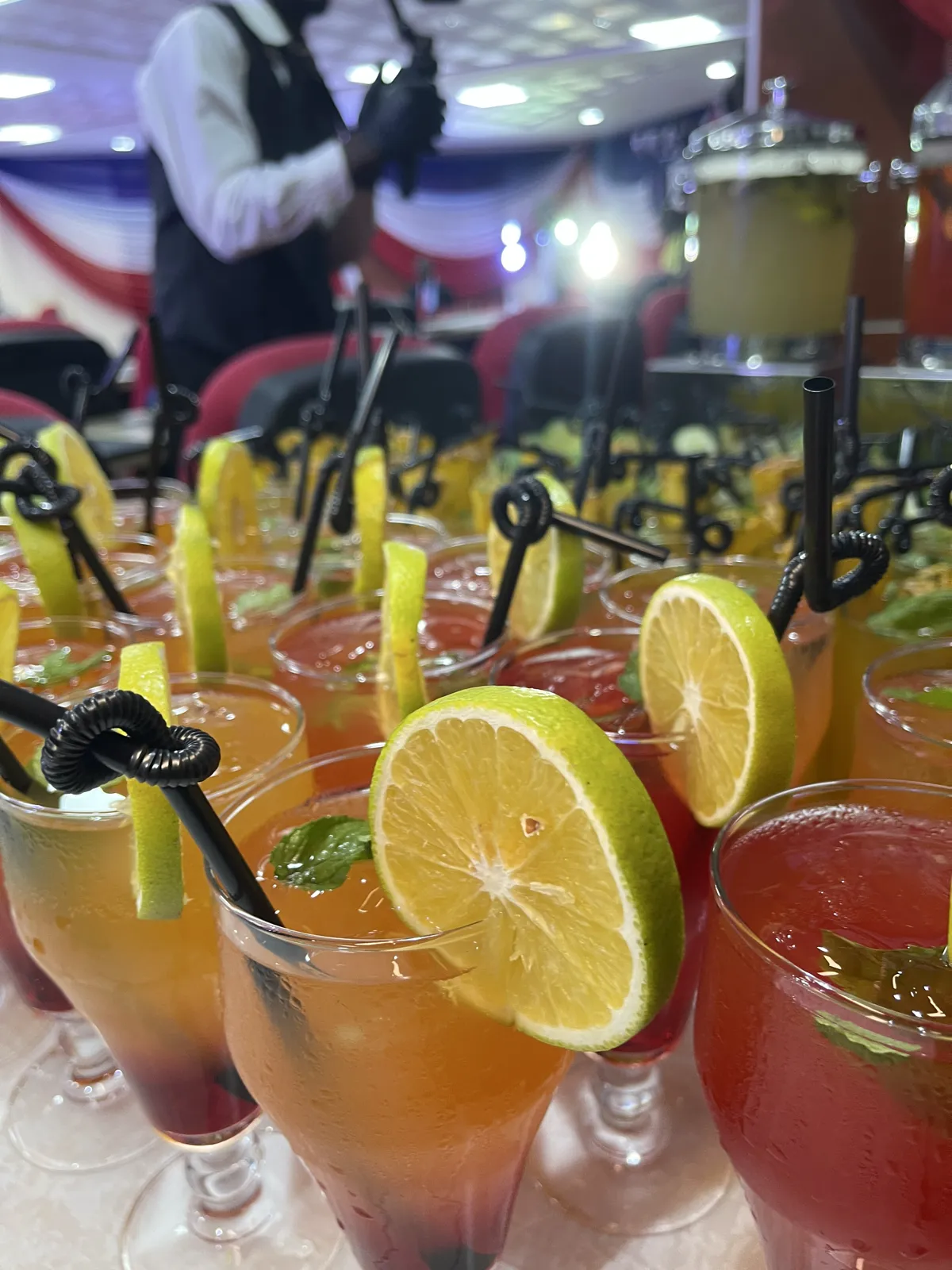 Colourful citrus mocktails garnished with lime slices and mint at an event