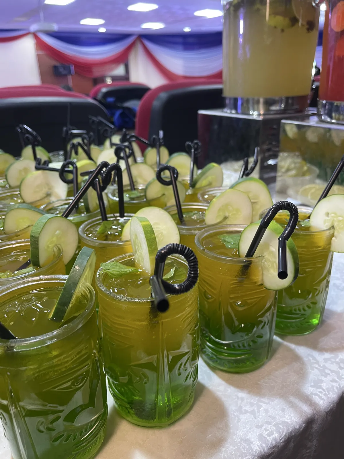 Cucumber and mint mocktails in patterned glasses at an event drinks station