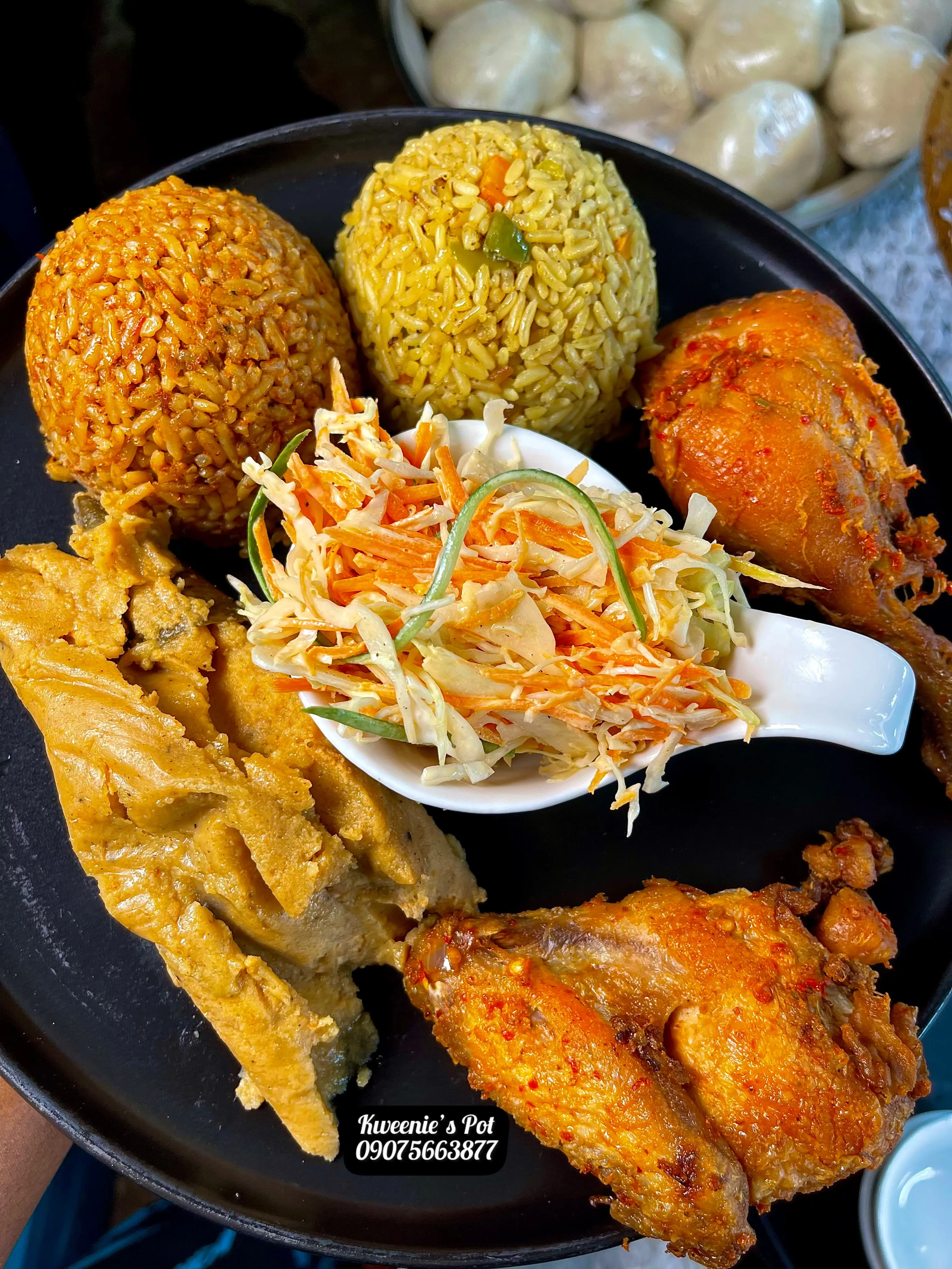Nigerian plate with jollof rice, fried rice, chicken, and coleslaw