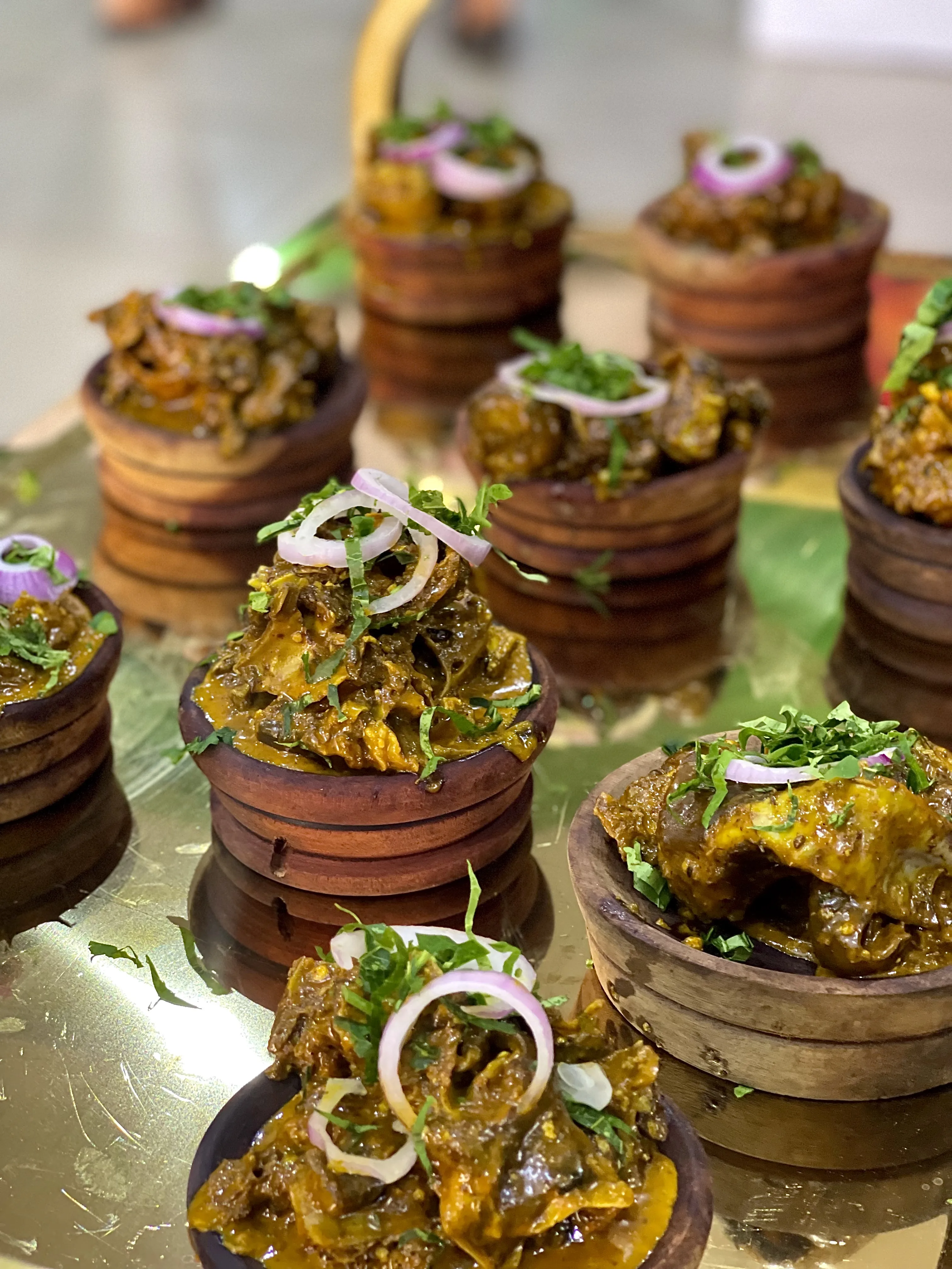 Peppered meat garnished with onions in wooden serving bowls