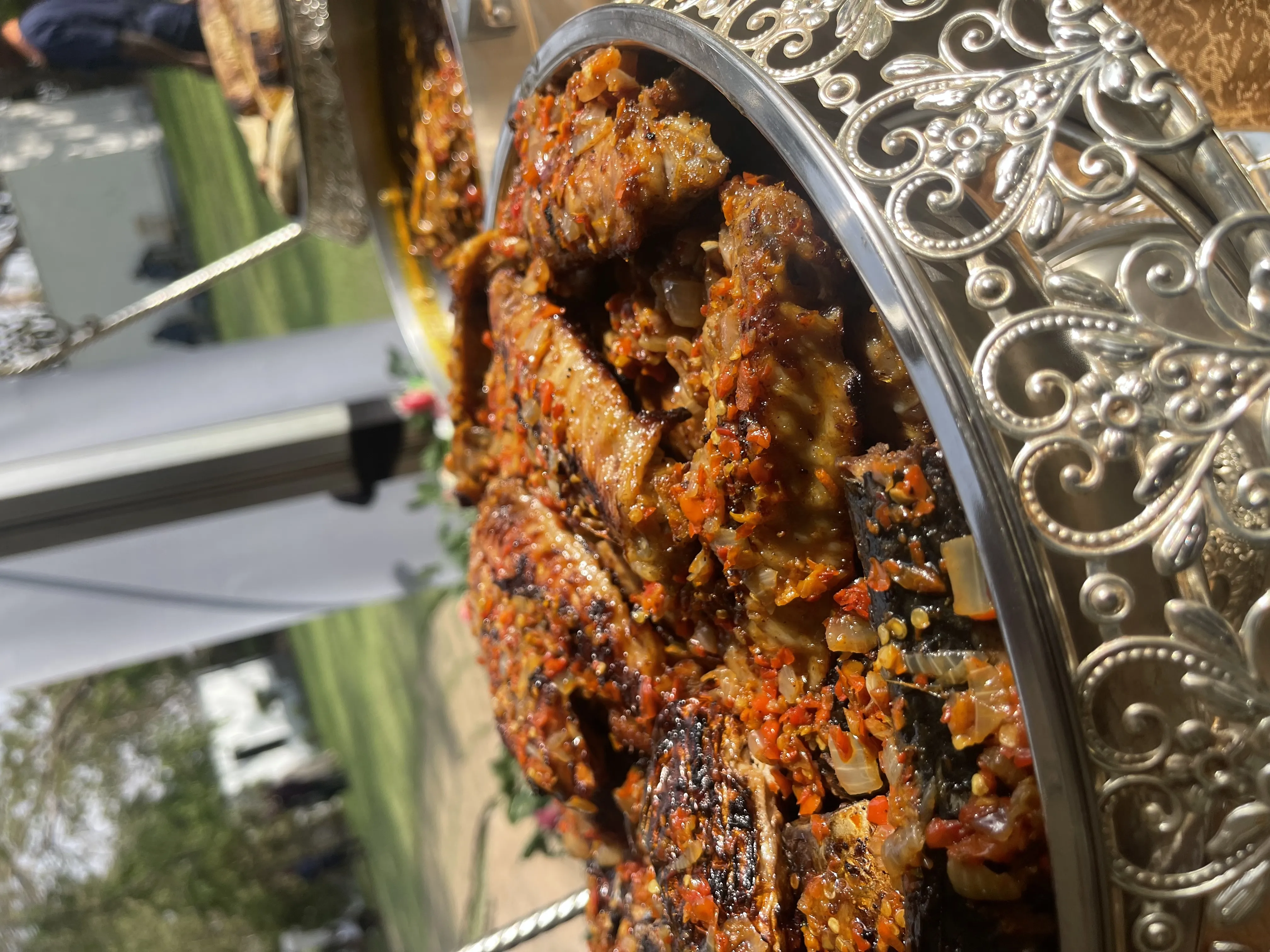 Peppered turkey in an ornate silver chafing dish at an outdoor event